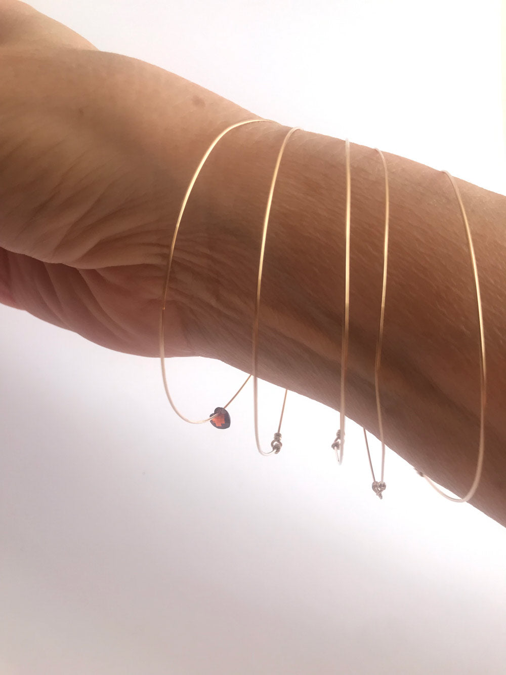 Bracciali 5 sensi con cuoricino di zircone rosso creati da Lucillazadra, indossati